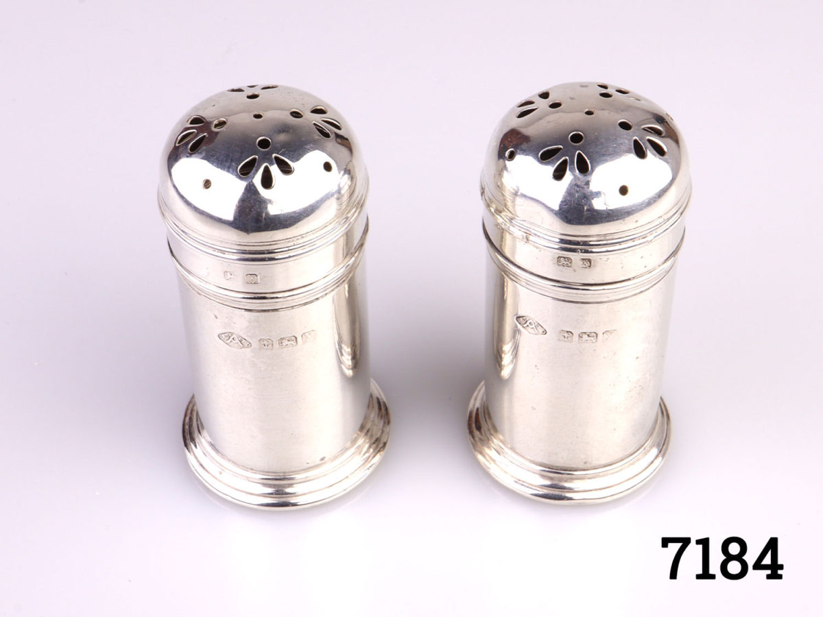 c1922 Birmingham assayed pair of sterling silver pepperettes by Adie Bros. Each pot measures 28mm in diameter and 55mm tall Photo of both pepperettes side by side taken from a slight raised angle