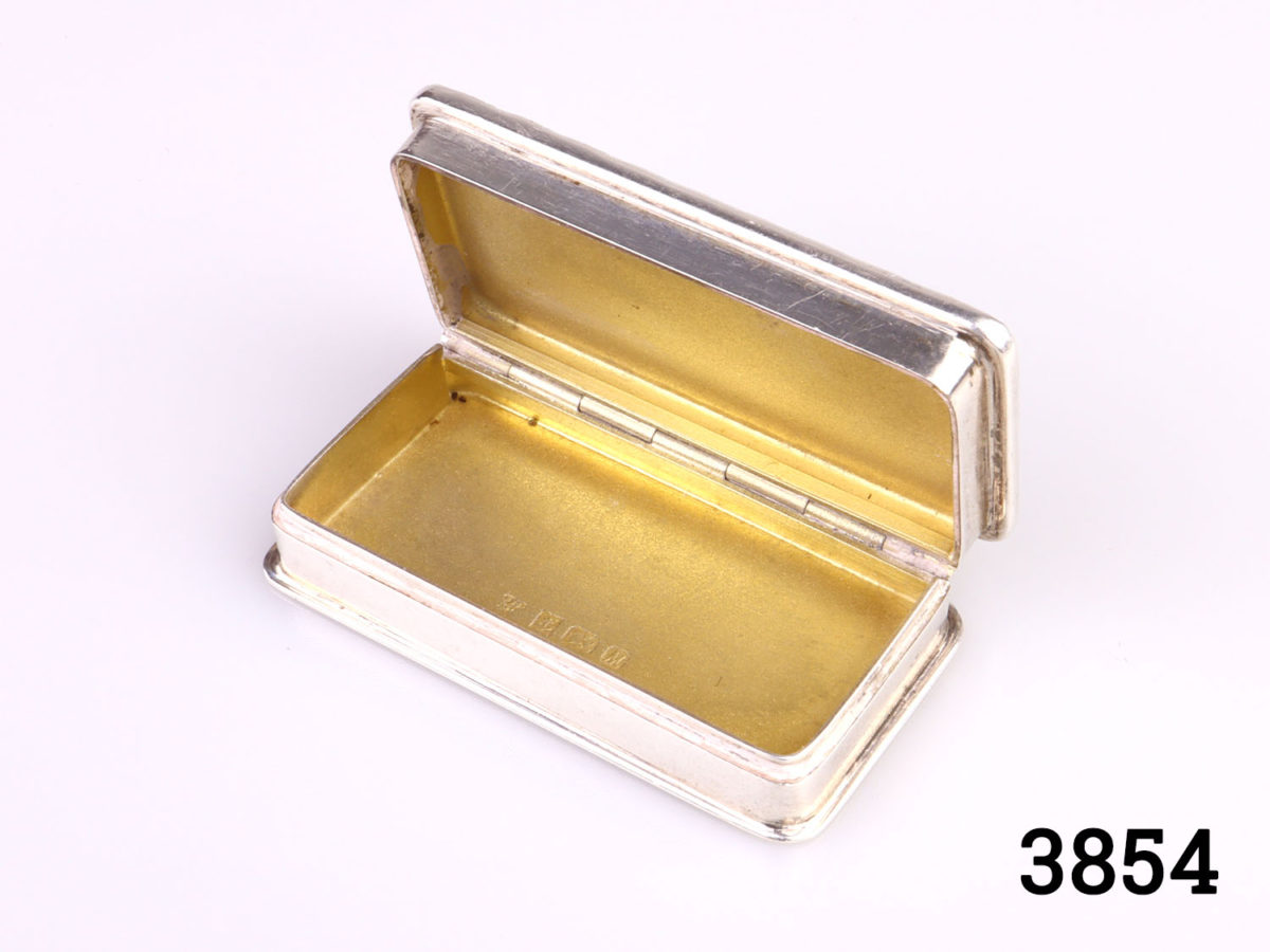 c1986 Birmingham assayed solid sterling silver pill/snuff box with gilt interior. Full hallmark on the inside (Burghley House in Lincolnshire to the lid) Photo of box with lid open showing the gilt interior of lower half of box