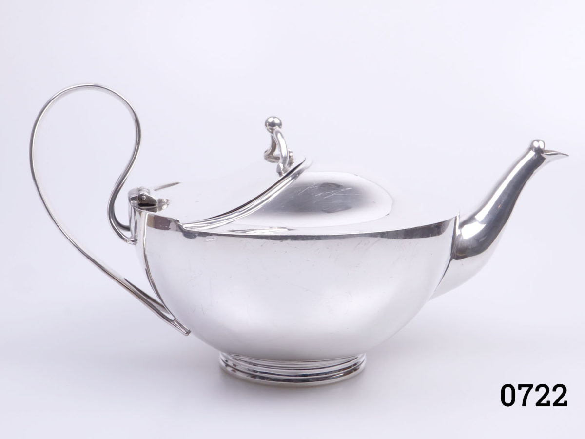 c1930s silver plate tea pot with evercool handle. Ali Baba style shape. Made by John Sherwood & Sons Base measures 67mm in diameter. Main photo of tea pot from the side showing the Ali Baba style shape