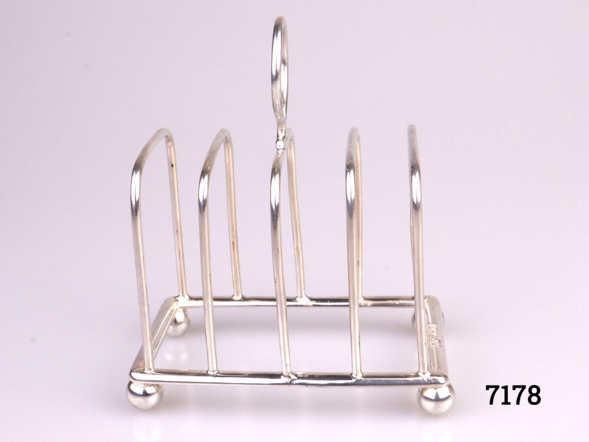 Antique sterling silver toast rack with ball feet. Fully hallmarked for Chester assay c1904 by maker J.J (Probably James Charles Jay) Photo of rack from the side