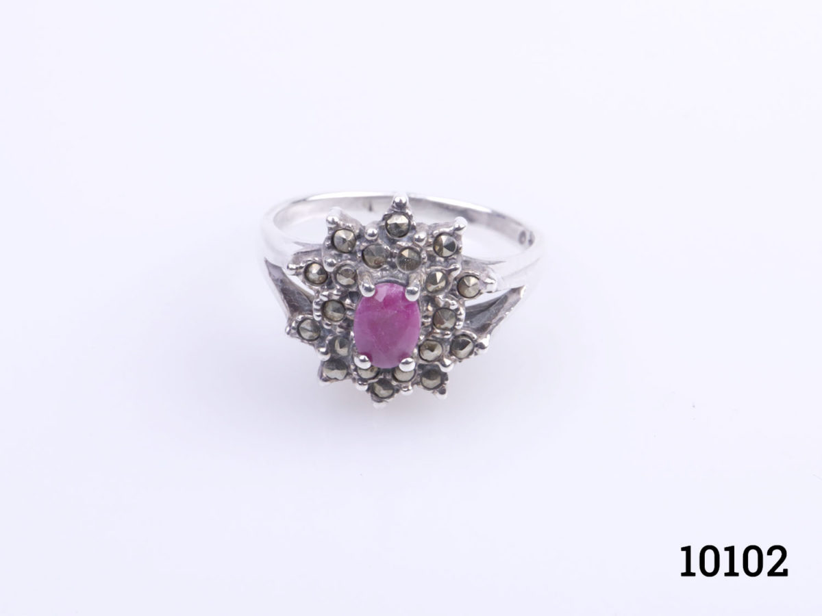 Vintage Art Deco style sterling silver and deep cerise coloured ruby ring. Oval cut ruby surrounded by marcasite Size O.5 / 7.25 Ring weight 4.4grams Photo of ring on a flat surface showing the frontage