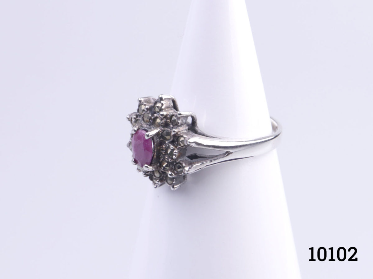 Vintage Art Deco style sterling silver and deep cerise coloured ruby ring. Oval cut ruby surrounded by marcasite Size O.5 / 7.25 Ring weight 4.4grams Photo of ring on display stand from a side angle