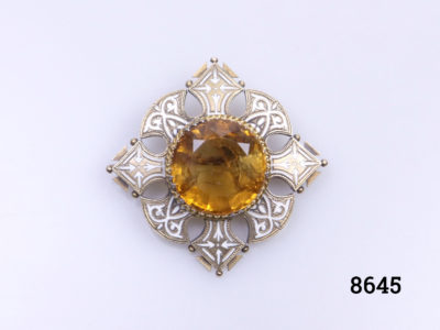 Vintage Celtic brooch with amber coloured stone to centre surrounded by enamelled brass in a Celtic design Main photo of brooch show with pointed sides at N S E & W