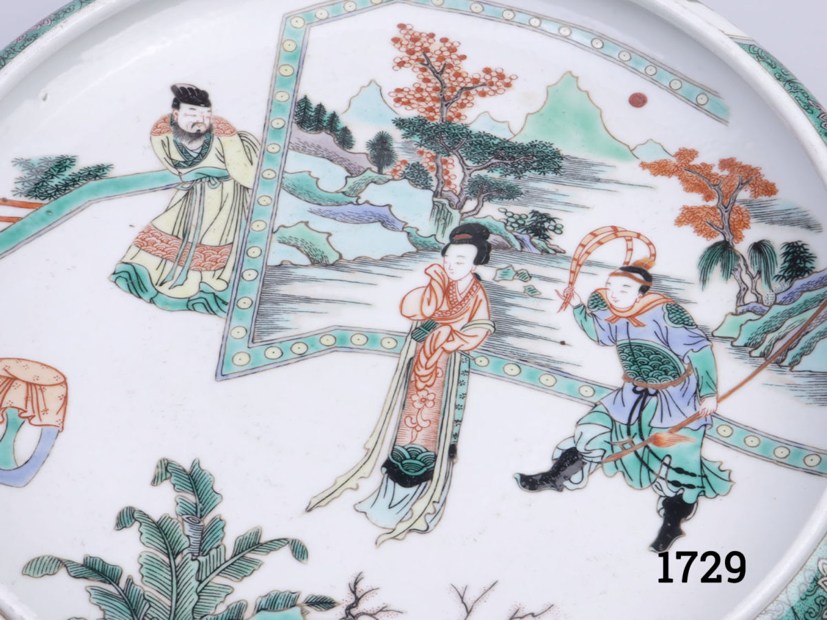 Vintage Chinese Famille Verte porcelain dish. Rolled rim and decorated with figures standing in front of panel screen. Six character mark to the base. Measures 190mm in diameter at base and 275mm in diameter across the top. Close up photo of the decorative scene to the centre of the dish