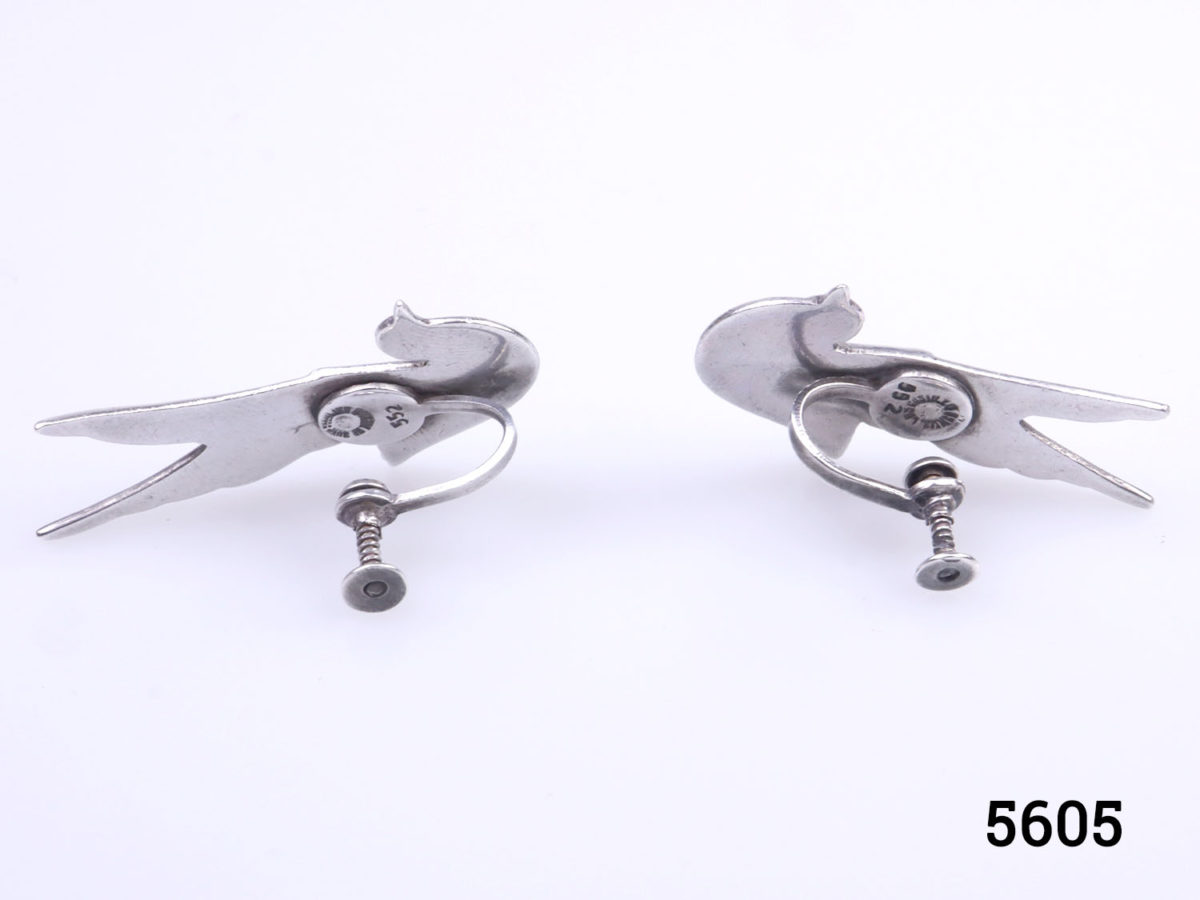 Vintage Mexican silver screwback bird earrings by Taxco. To be worn with the birds wings to go up along the outer ear lobe. Each earring measures 38mm at highest point and 22mm at widest. Earrings weigh 12g Photo of back of both earrings showing the screw-back