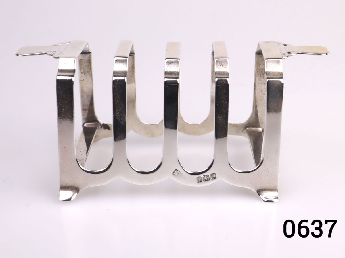 Pair of Art Deco sterling silver toast racks. Fully hallmarked for c1938 Birmingham assay. Each measures 112mm long across the top 50mm at widest point and 52mm tall. Photo of the rack from the side showing the dividers