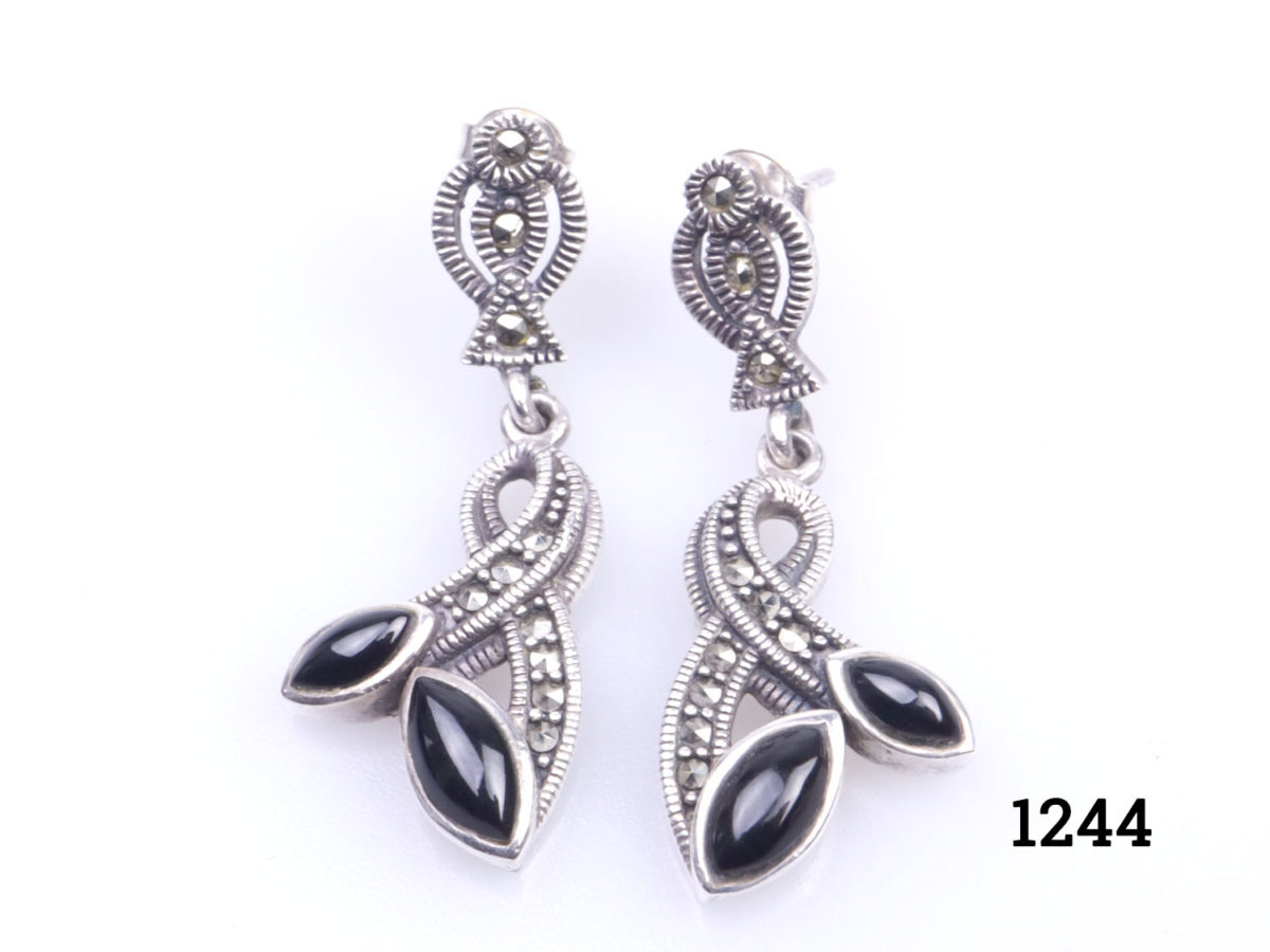 Art Deco style sterling silver, marcasite and black onyx earrings. Drop length 36mm. Main photo showing earrings on a flat surface and laid side by side