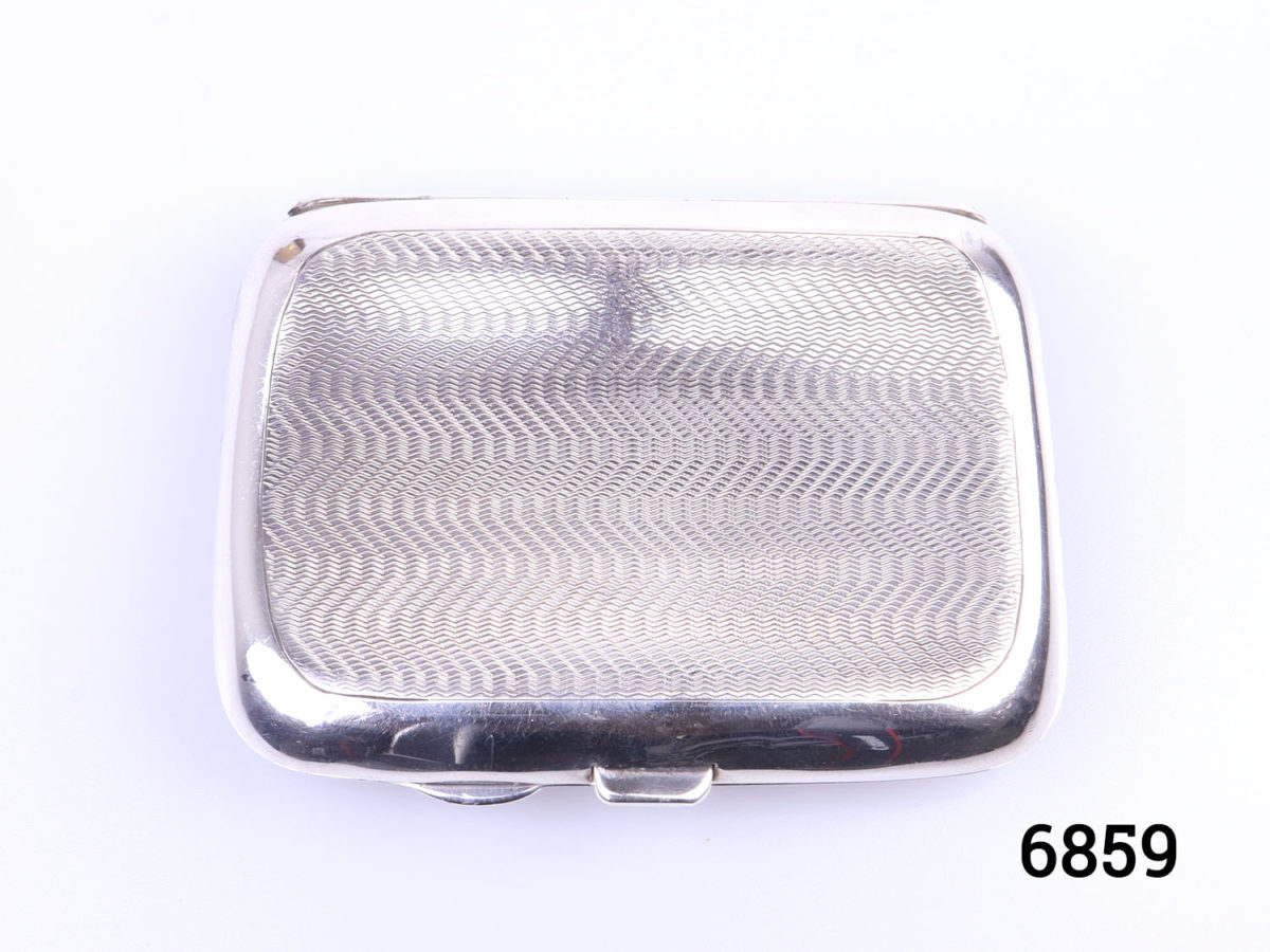 c1935 Birmingham assayed sterling silver small engine turned pocket cigarette case. Initialled RH on cartouche. Both elastic intact inside. Photo of back of case looking down from above (non cartouche side)