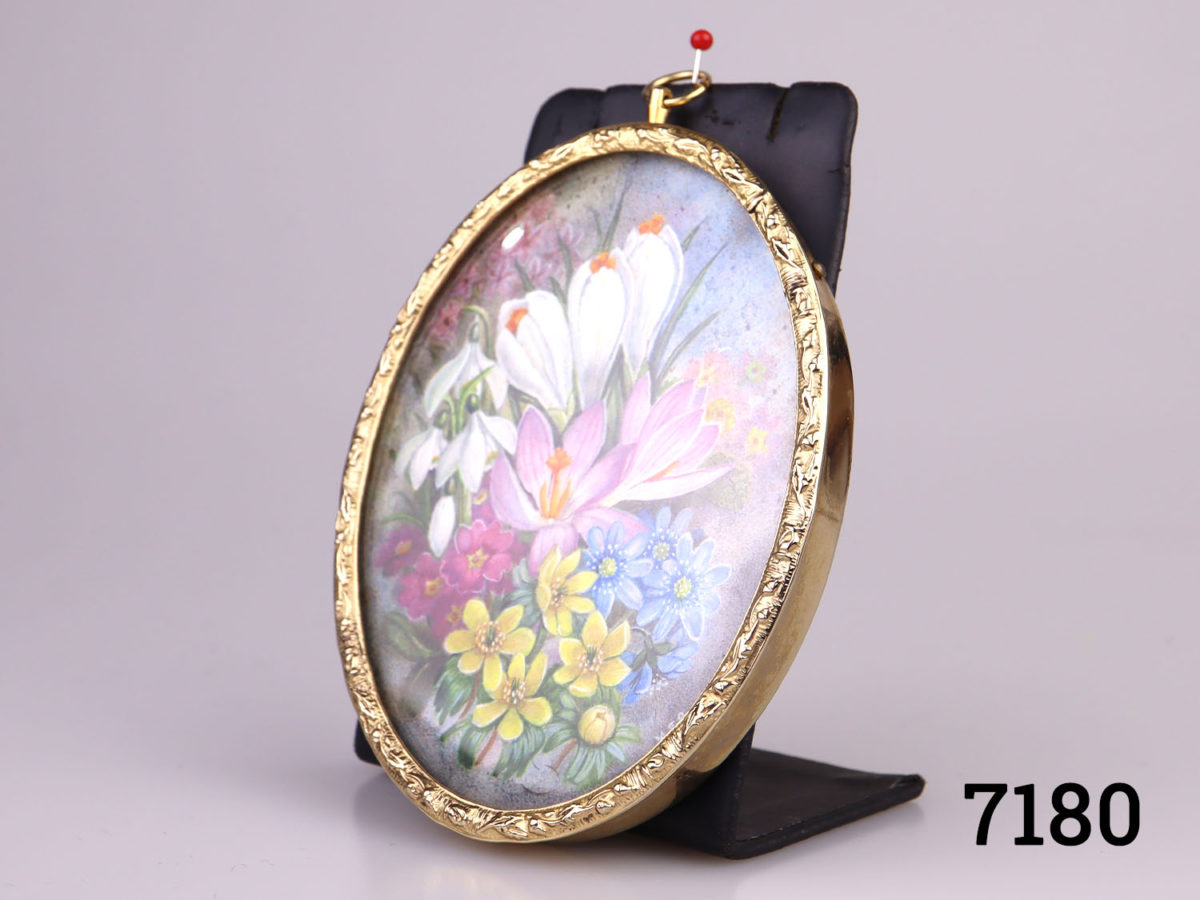 Small vintage hand-painted picture in a gilt metal oval frame. Hand-painted with spring flowers and signed M.E.R