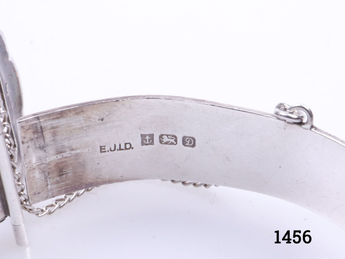 c1978 Birmingham assayed vintage sterling silver bracelet. Solid silver bracelet in popular 70s buckle design. Made by Excalibur jewellery Ltd. Open gap measures 50mm wide. Closed bangle measures approximately 60mm in diameter. Width at buckle 20mm. Close up photo of the Birmingham assay hallmark