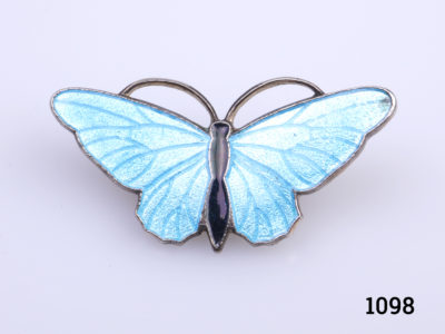 Vintage blue enamel butterfly brooch. Turquoise blue wings and black enamel body on gilt metal.