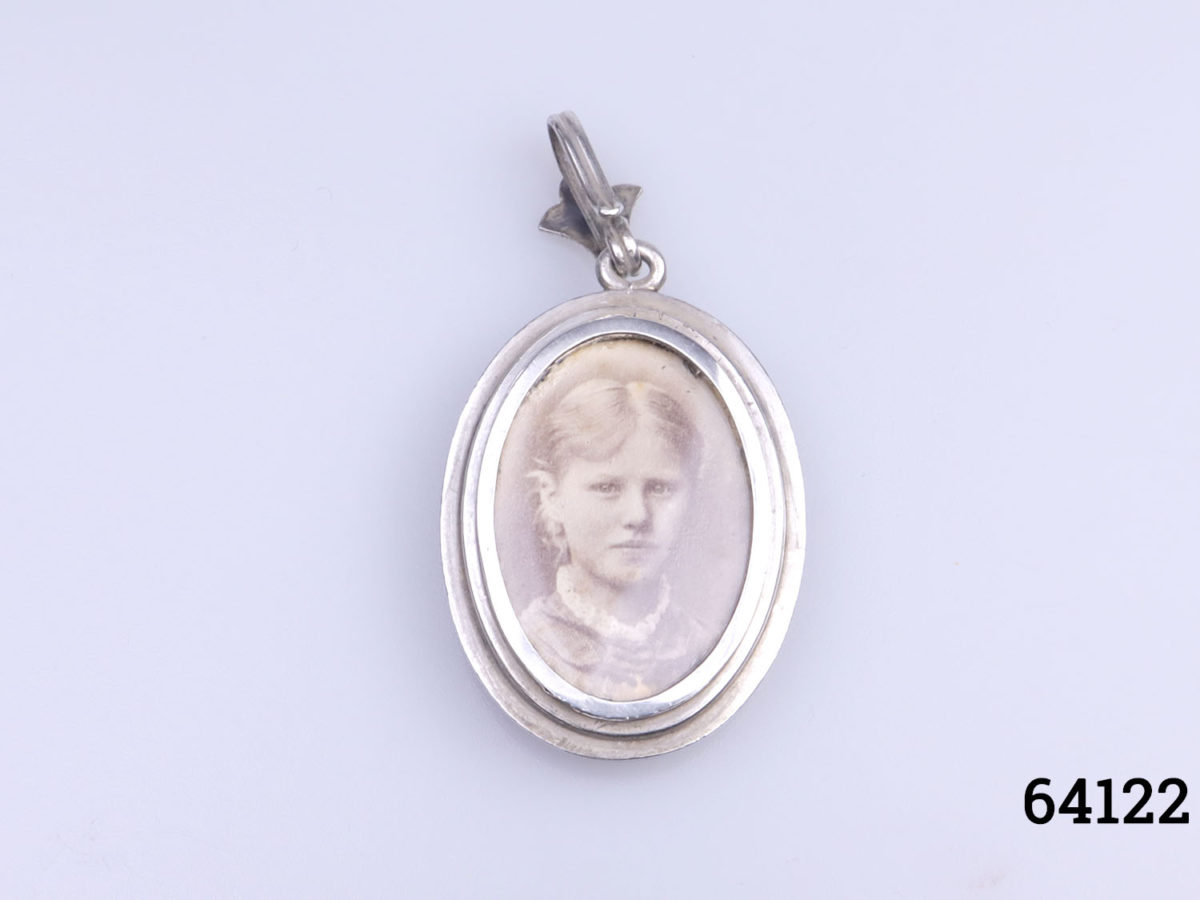 Antique Victorian open window locket decorated with an anchor to the front. Open window portrait to the back which removes to reveal space for storing a small keepsake. Drop length front top of bail to bottom of locket 54mm Photo of back of pendant showing photograph of young lady