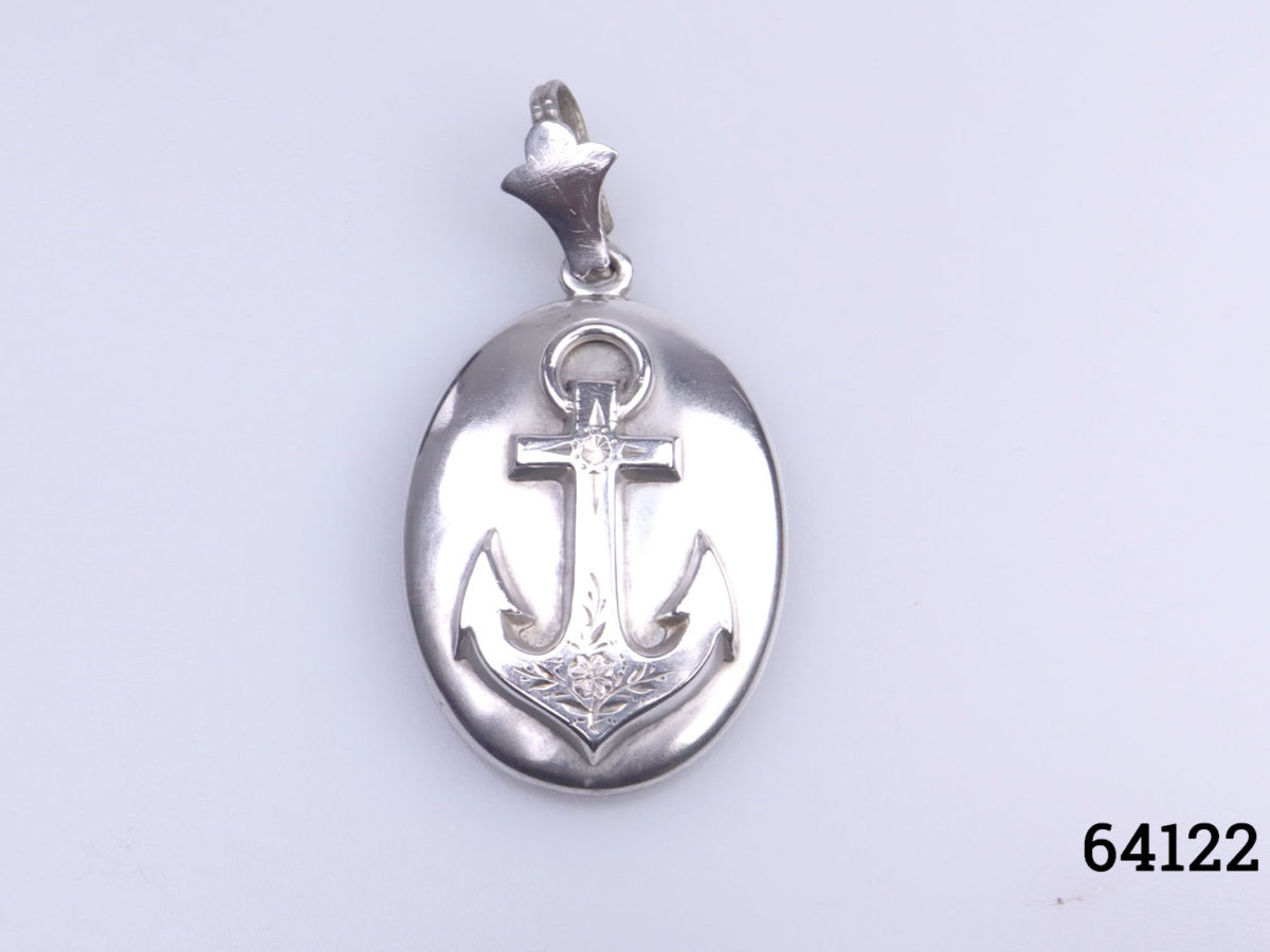 Antique Victorian open window locket decorated with an anchor to the front. Open window portrait to the back which removes to reveal space for storing a small keepsake. Drop length front top of bail to bottom of locket 54mm Main photo of locket on a flat surface with anchor side showing