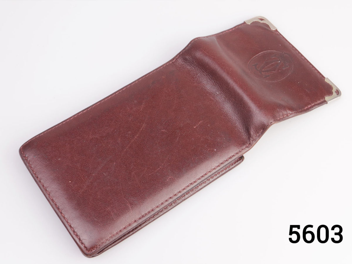 Vintage fine leather Cartier cigarette pouch in a rich maroon tan colour. White metal corner guards on each opening tab corner and famous Cartier logo embossed in the centre to the tab. (Very useful as a card holder) Photo of case shown from the back and open