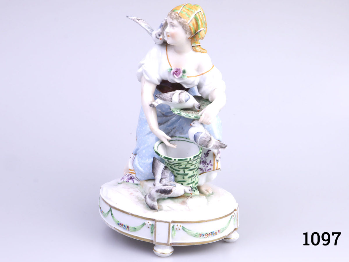 Vintage Continental porcelain figurine of a young lady feeding pigeons from a basket. No makers mark but numbered 1715 to base. Possibly German. (Some gilt wear to the base) Photo of lady from a side view