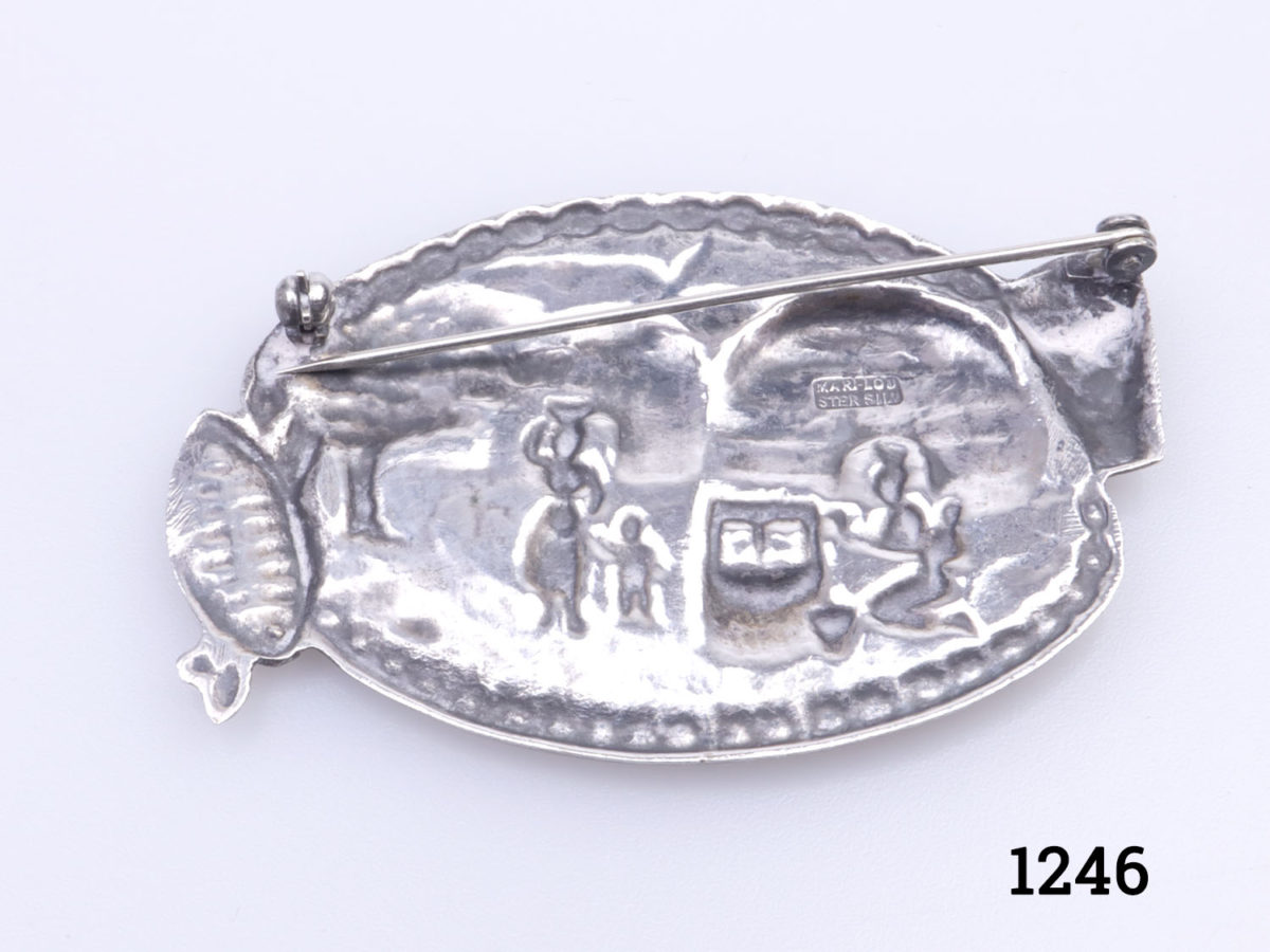 Vintage 1970s sterling silver brooch by Mari Lou Pretoria. Decorated with scene of rural Zulu village with huts. Zulu shield to the right and drum to the left. Signed Mari Lou to the back and hallmarked for sterling silver. Photo of back of brooch