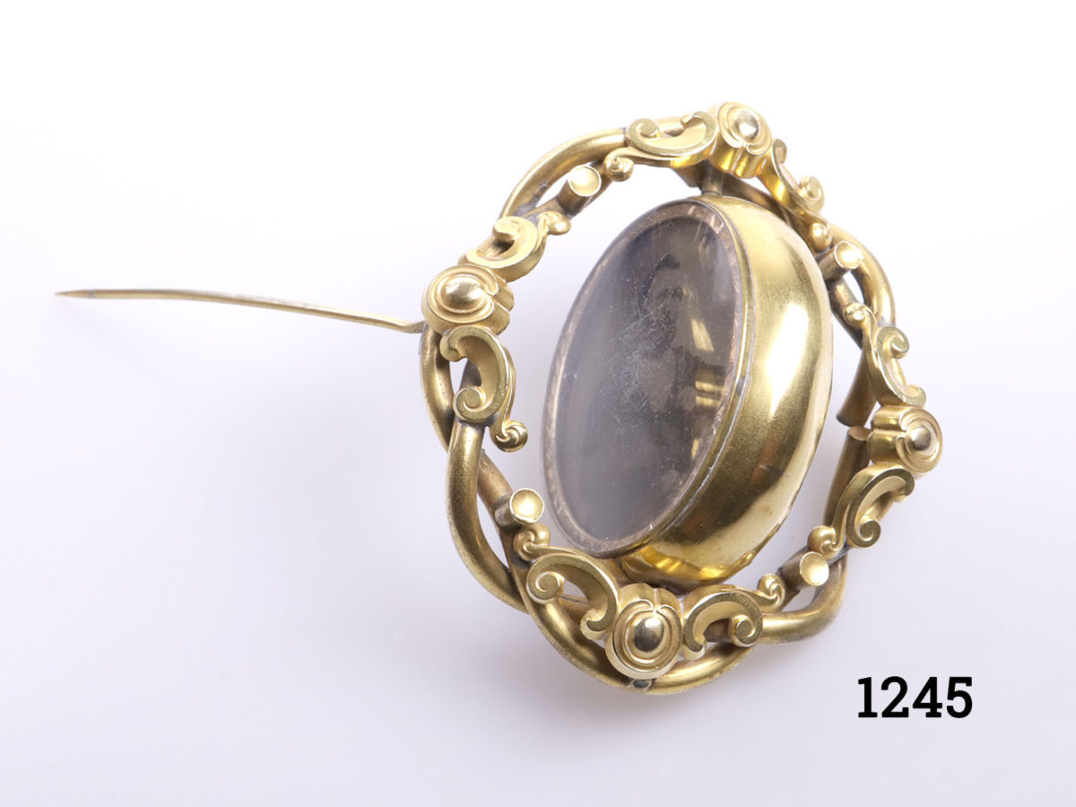 Large pinchbeck mourning brooch with rotating centre. Portrait of distinguished gentleman on one side and reverse blank Photo of brooch showing the middle section mid ay from being reversed/turned