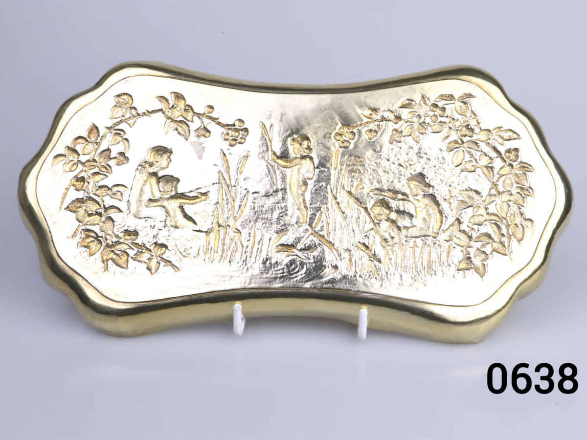 c1901 London assayed gilt silver oblong dish. Decorated with embossed scene of a family playing by the river bank with reeds and brambles. Fully hallmarked for sterling silver and made by William Comyns & Sons Photo of back view of dish displayed on stand