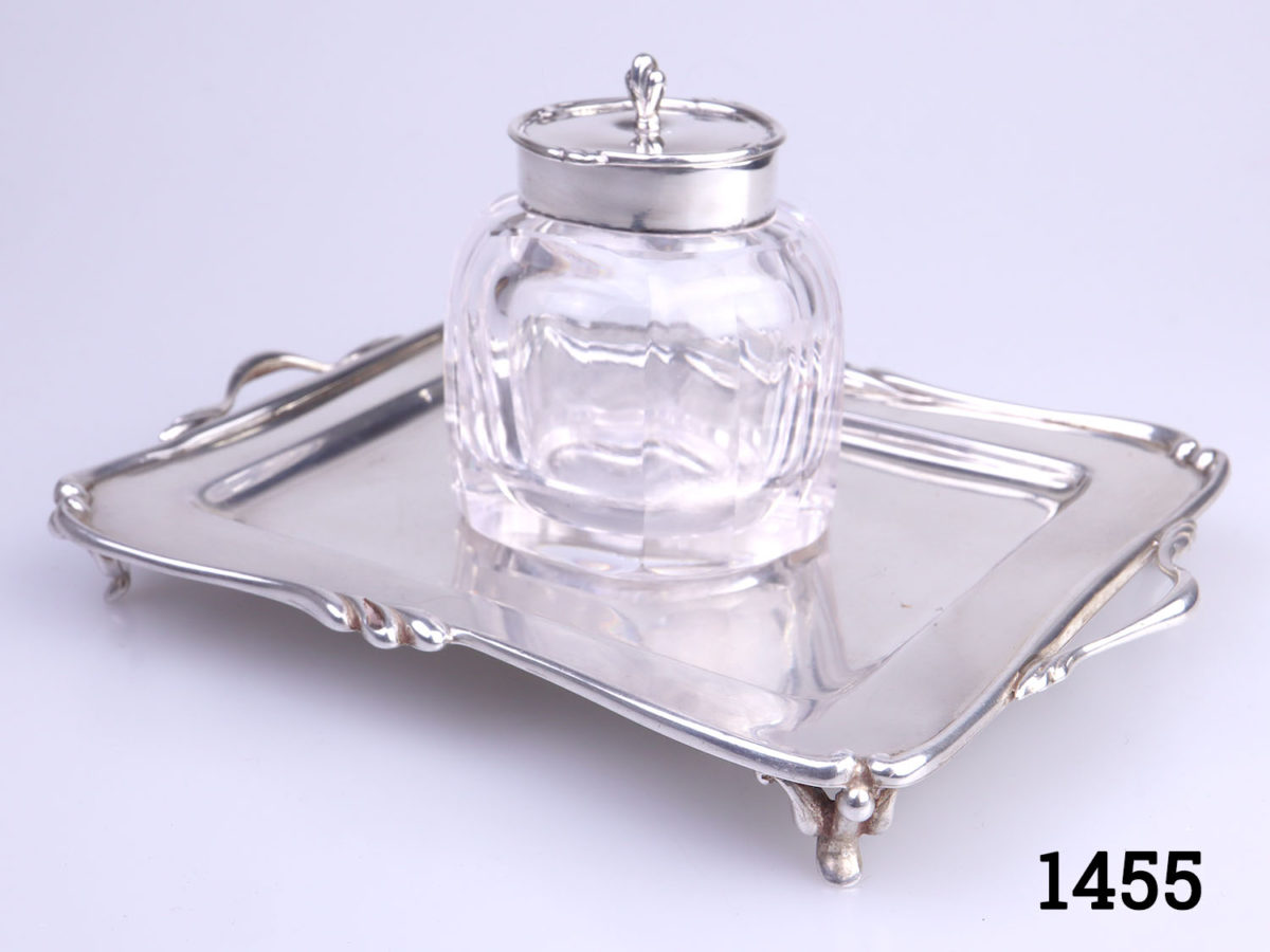 c1907 Birmingham assayed sterling silver and cut glass inkwell and stand. Inkwell sits securely in the hole in the centre of the stand. Inkwell weighs 190.6grams and measures 52mm x 45mm and 70mm tall. Stand measures 150mm long (including handles) and 110mm wide and weighs 95grams Photo of inkwell set on tray from a slight side angle