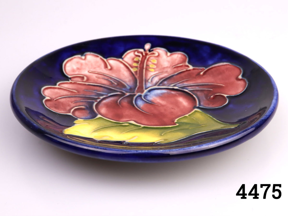 c1950s Vintage Moorcroft small circular dish. Classic Moorcroft royal velvet blue background with iconic hibiscus design. Measures 115mm in diameter. Min photo of plate from just above eye level view