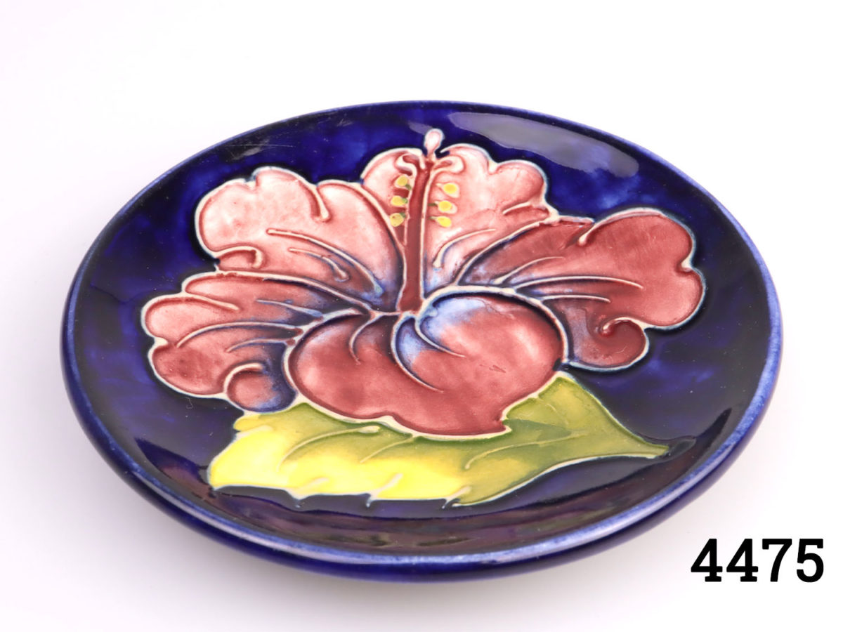 c1950s Vintage Moorcroft small circular dish. Classic Moorcroft royal velvet blue background with iconic hibiscus design. Measures 115mm in diameter. Photo looking down at plate from above