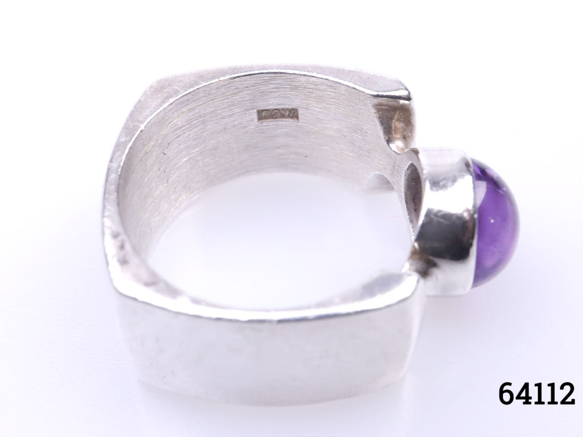 c1974 Peter Guy Watson ring. Modernist sterling silver ring with unusual square cut band and amethyst stone to the centre. Band width 10mm. Ring size Q / 8 Ring weight 12.6grams Photo of makers initials PGW on the inner band