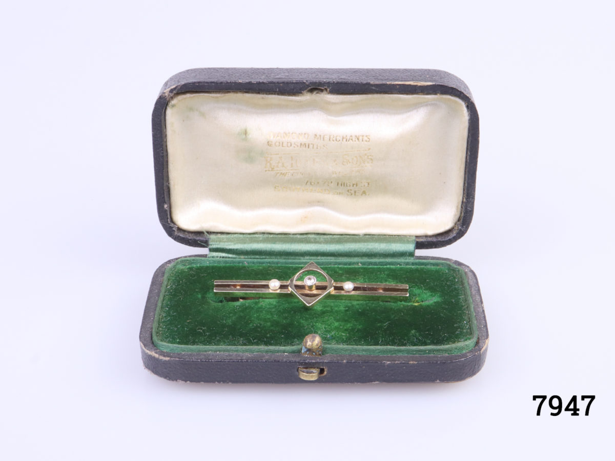 Vintage 15 karat gold bar brooch with 2 small seed pearls and clear stone to the centre. Comes in original box. Brooch weight 2.3g Photo of brooch in original box