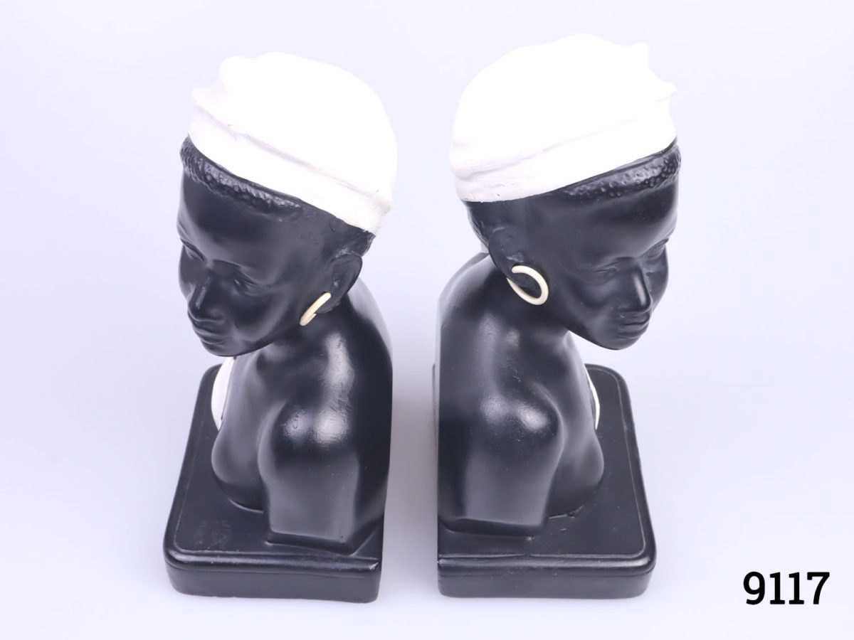 c1950s Duron bookends in the form of African ladies. Both figures looking outward with contrasting white head gear and earrings. Numbered 6010 the back with Reg No.883679 Each measures approximately 90mm long and 65mm wide Photo looking down onto bookends from a slight raised angle