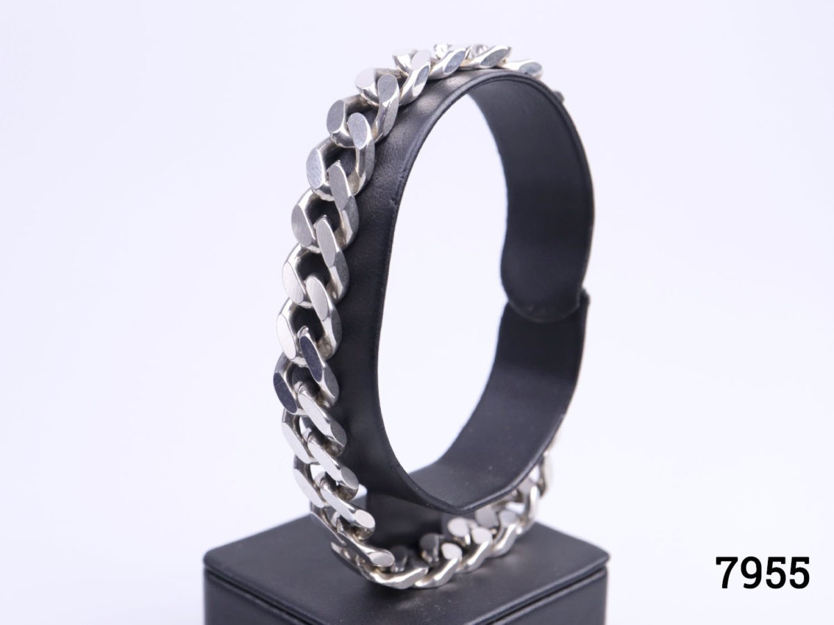 1970s solid sterling silver curb chain bracelet. Hallmarked 925 for sterling silver Photo of bracelet displayed on stand seen from a sideways angle