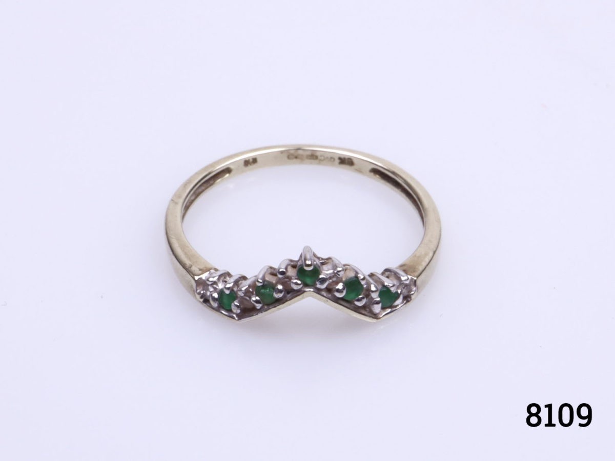 Vintage 9 karat gold ring. Wishbone shape to the front and set with 5 small emeralds and 6 small diamonds. Size P.5 / 7.75. Ring weight 1.9 Photo of ring on a flat surface seen from the front