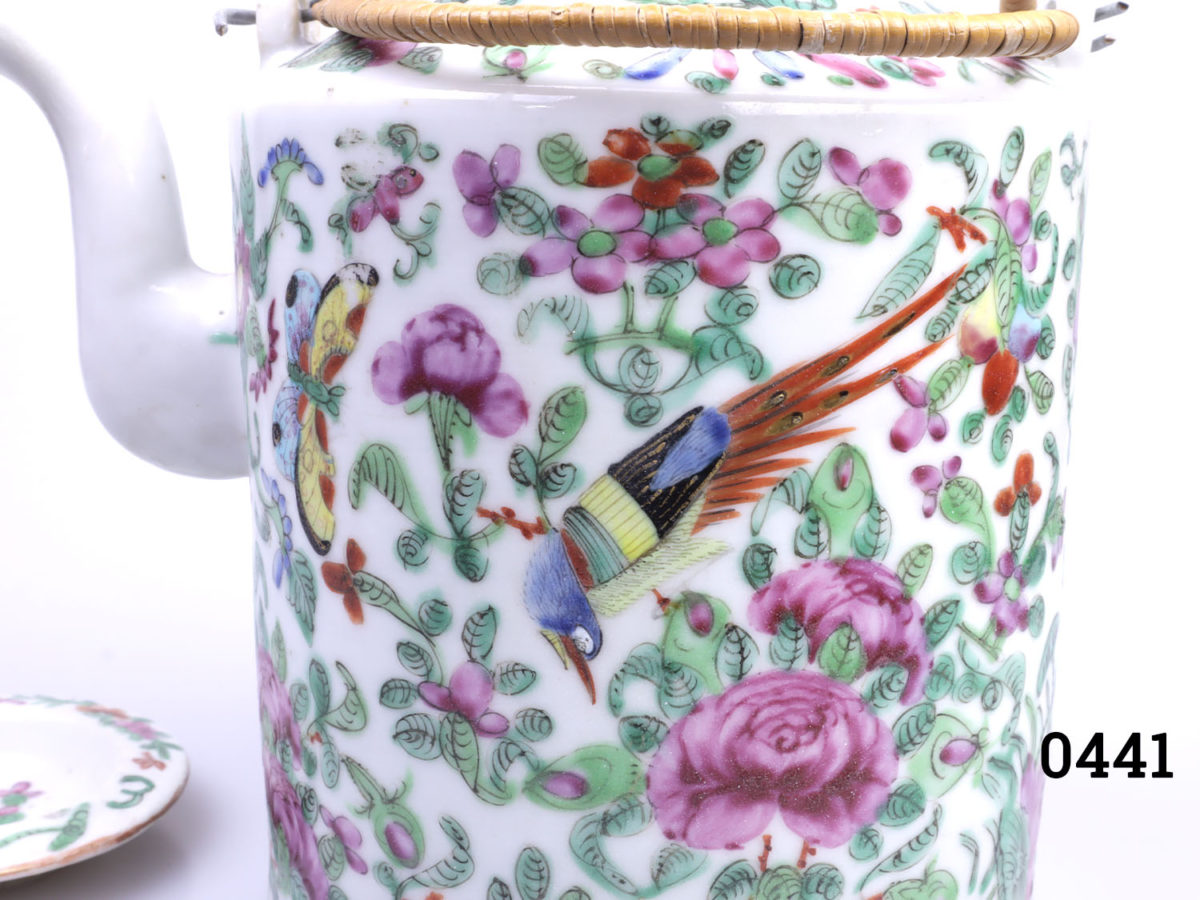 Antique Famille Rose teapot. Hand-decorated in a floral scene with birds and butterflies. (The spout tip has had a professional repair). Measures 130mm in diameter at base and 210mm tall with handle extended. Close up photo of some of the hand-painted decoration (bird & flowers)
