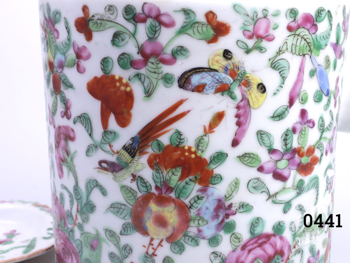Antique Famille Rose teapot. Hand-decorated in a floral scene with birds and butterflies. (The spout tip has had a professional repair). Measures 130mm in diameter at base and 210mm tall with handle extended Close up photo of hand-painted decoration (butterfly & flowers)
