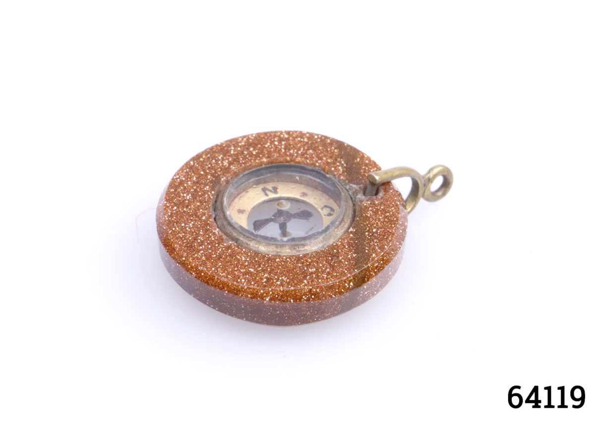 Antique goldstone compass fob. Miniature compass set in a ring of sparkly goldstone and mounted on brass. Comes in box and pouch. Measures 20mm in diameter and weighs 3.6g. Photo of fob with brass clasp to the right