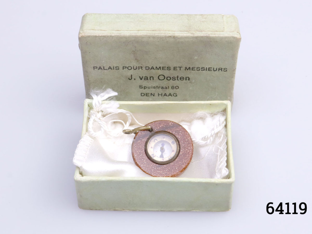 Antique goldstone compass fob. Miniature compass set in a ring of sparkly goldstone and mounted on brass. Comes in box and pouch. Measures 20mm in diameter and weighs 3.6g. Photo of fob compass in box with lid of box leaning up at the back