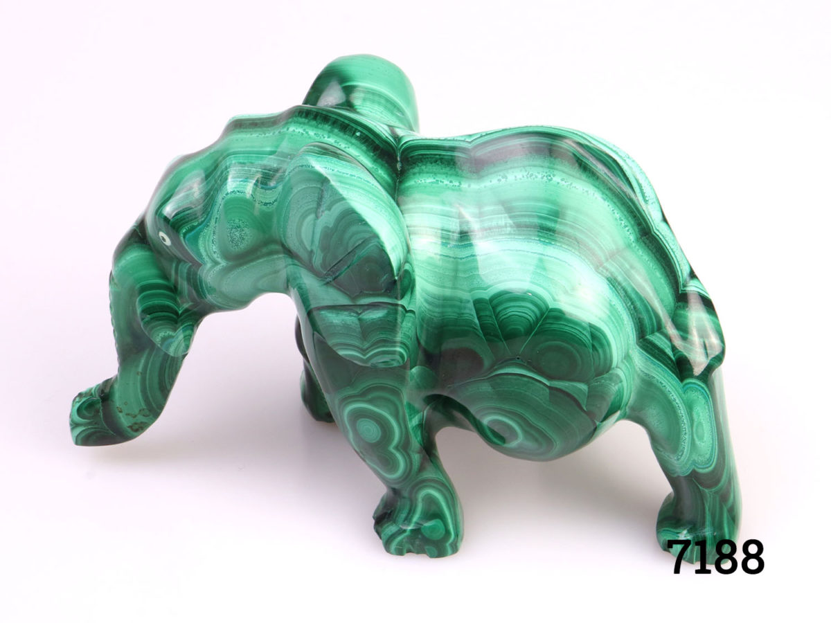 Heavy elephant ornament carved out of one piece of malachite. Smooth finish with no rough edges. Photo of elephant from the side (trunk to left)