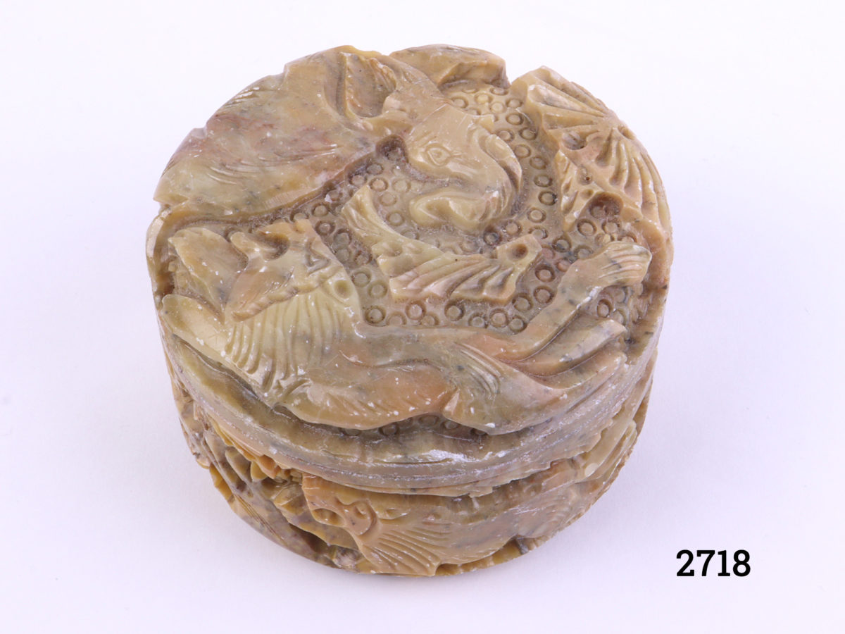 Carved soapstone lidded pot decorated with lion and elephant to the lid and lions and deer to the sides Measures 80mm in diameter Main photo showing pot from a slight raised angle showing depth