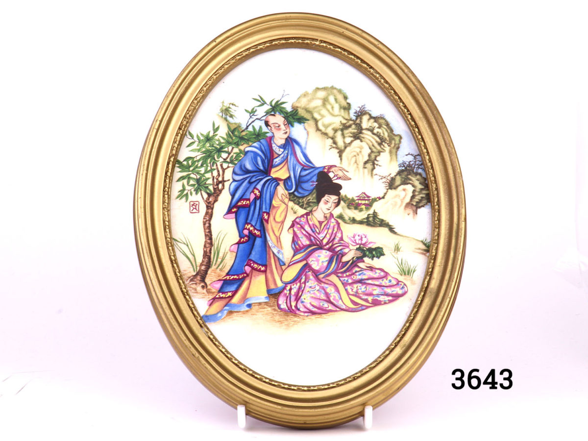 Pair of vintage oval gilt framed Oriental porcelain pictures. Hand-painted with scenes of courting couples in an Oriental setting. Felt peeling at back. Photo of picture with lady seated and holding a peony flower and man standing behind her