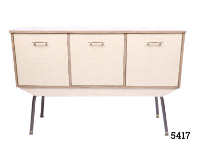 1970s Retro melamine sideboard with 3 compartments; cupboard to left with shelf, drop down central compartment and door concealing 3 drawers to the right. Measurement at base (legs) 1105mm by 355mm Main photo of sideboard looking straight on at front