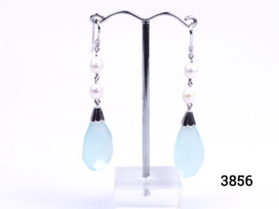 Unique sterling silver dangle earrings with pearls and tear drop shaped faceted natural aquamarine. Hook fastening for pierced ears. Hallmarked 925 for sterling silver. Drop length 65mm from top of hook. Aquamarine measures 15mm at widest point. Main photo of both earrings displayed on a stand