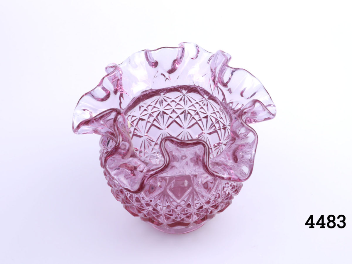 Vintage Fenton pale cranberry glass vase. Crinkle rimmed lip and diamond shaped pattern to body. Measures 50mm in diameter at base and 125mm in diameter across the top Photo of vase seen from a raised angle looking down partially into interior
