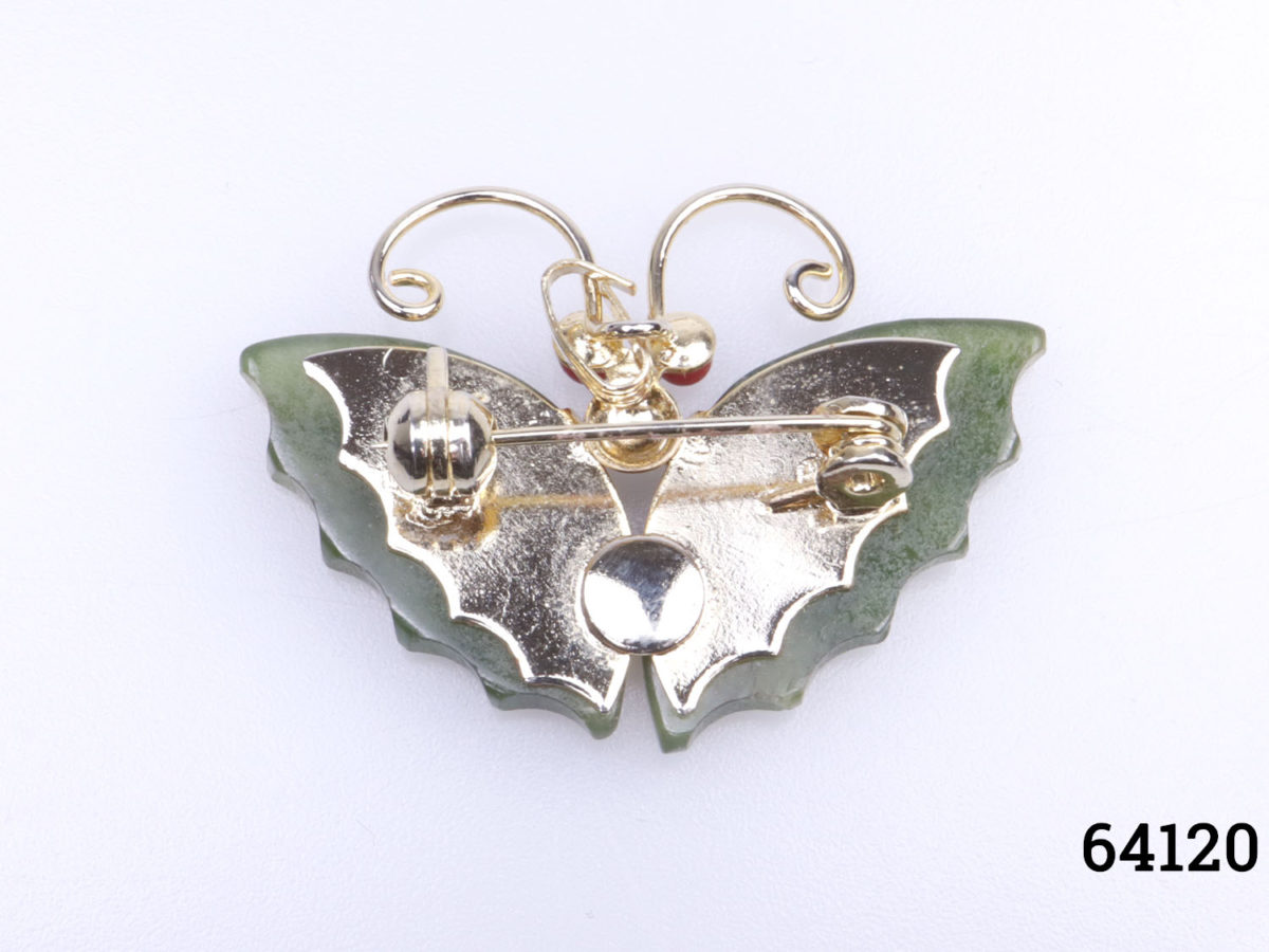 Vintage butterfly brooch with jade wings and coral eyes set on gilt metal Photo of back of brooch
