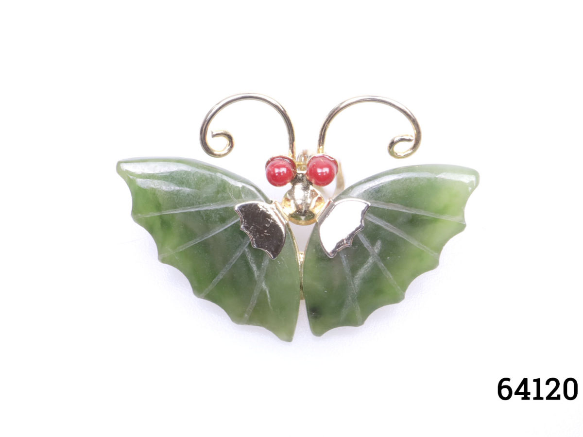 Vintage butterfly brooch with jade wings and coral eyes set on gilt metal Main photo showing brooch front