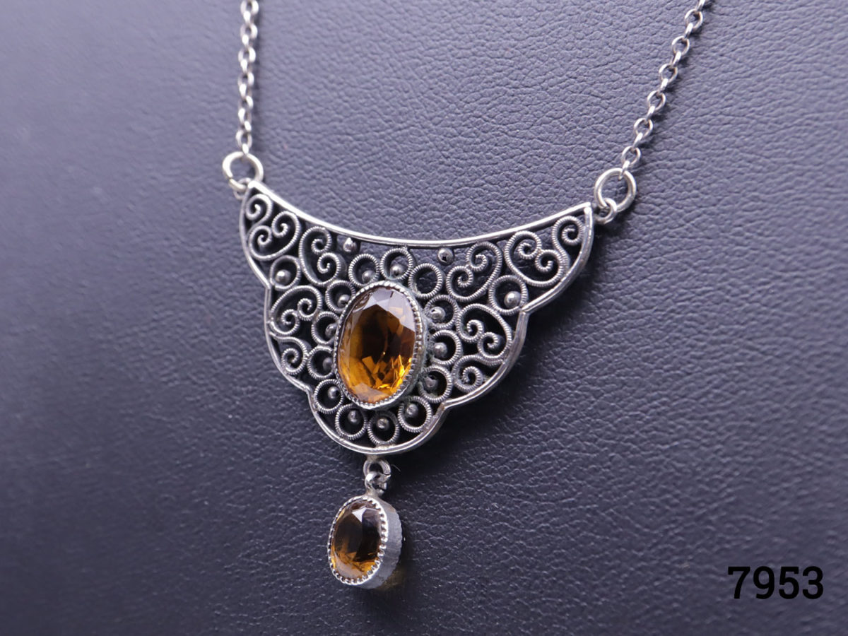 Vintage silver necklace with attached pendant. Pendant adorned with an oval cut orange stone to the centre and smaller orange stone hanging beneath. Pendant drop length 30mm Close up photo of the pendant seen at a slight sideways angle
