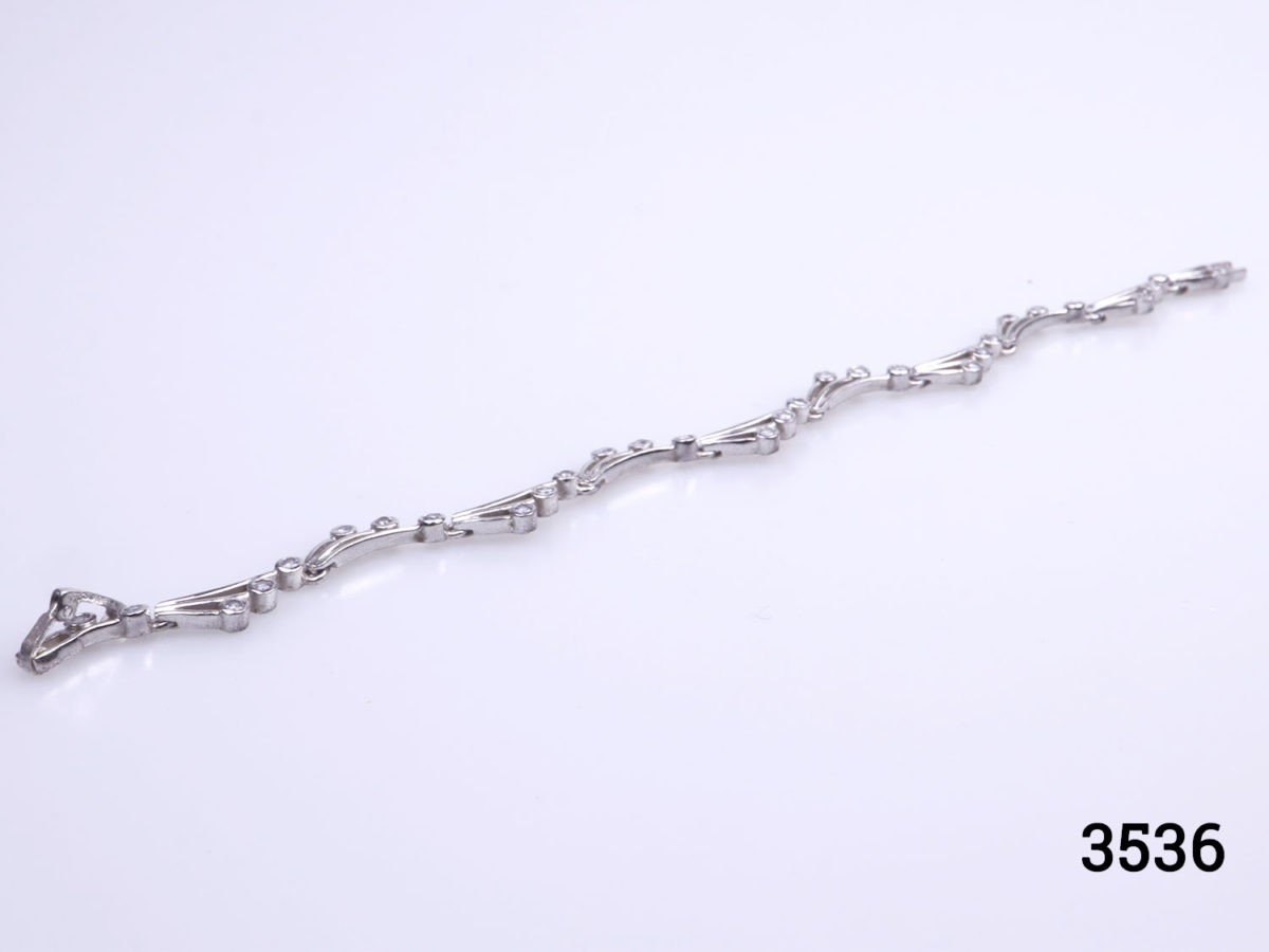 Vintage 925 sterling silver bracelet set with small cubic zirconia pieces in a wave like form. Hallmarked 925 Photo of bracelet on a flat surface front side up