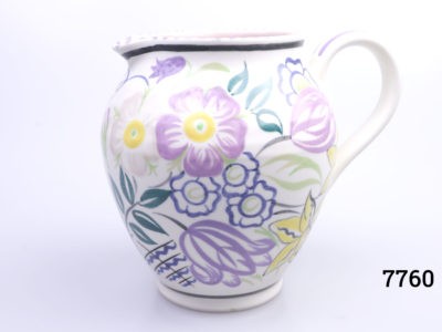Vintage small Poole Pottery jug with spring flowers in lilac, green and yellow with pale pink interior. (Tiny chip to the lip). Measures 60mm in diameter at base. Main photo showing jug from euye level with handle to the right