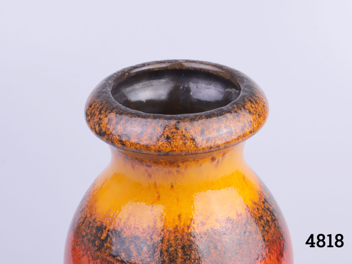 Mid 20th Century West German lava vase by Scheurich Keramik in hues of tequila sunrise over brown. Makers mark and serial number to base. Measures 80mm in diameter at base and 70mm in diameter across top. Photo of top of vase showing the lip and black interior