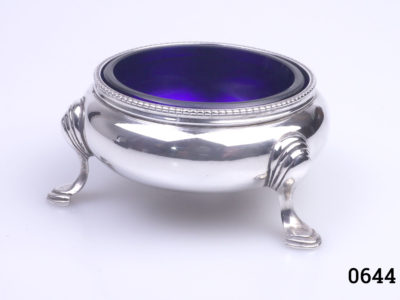 c1859 London assayed sterling silver salt by Robert Harper. Single salt on three legs with Bristol blue liner. Fully hallmarked to the base. (Small chip on blue liner) Top measures 60mm in diameter. Legs measure approximately 75mm apart. Main photo of salt with blue glass liner in place and 2 of the 3 legs showing