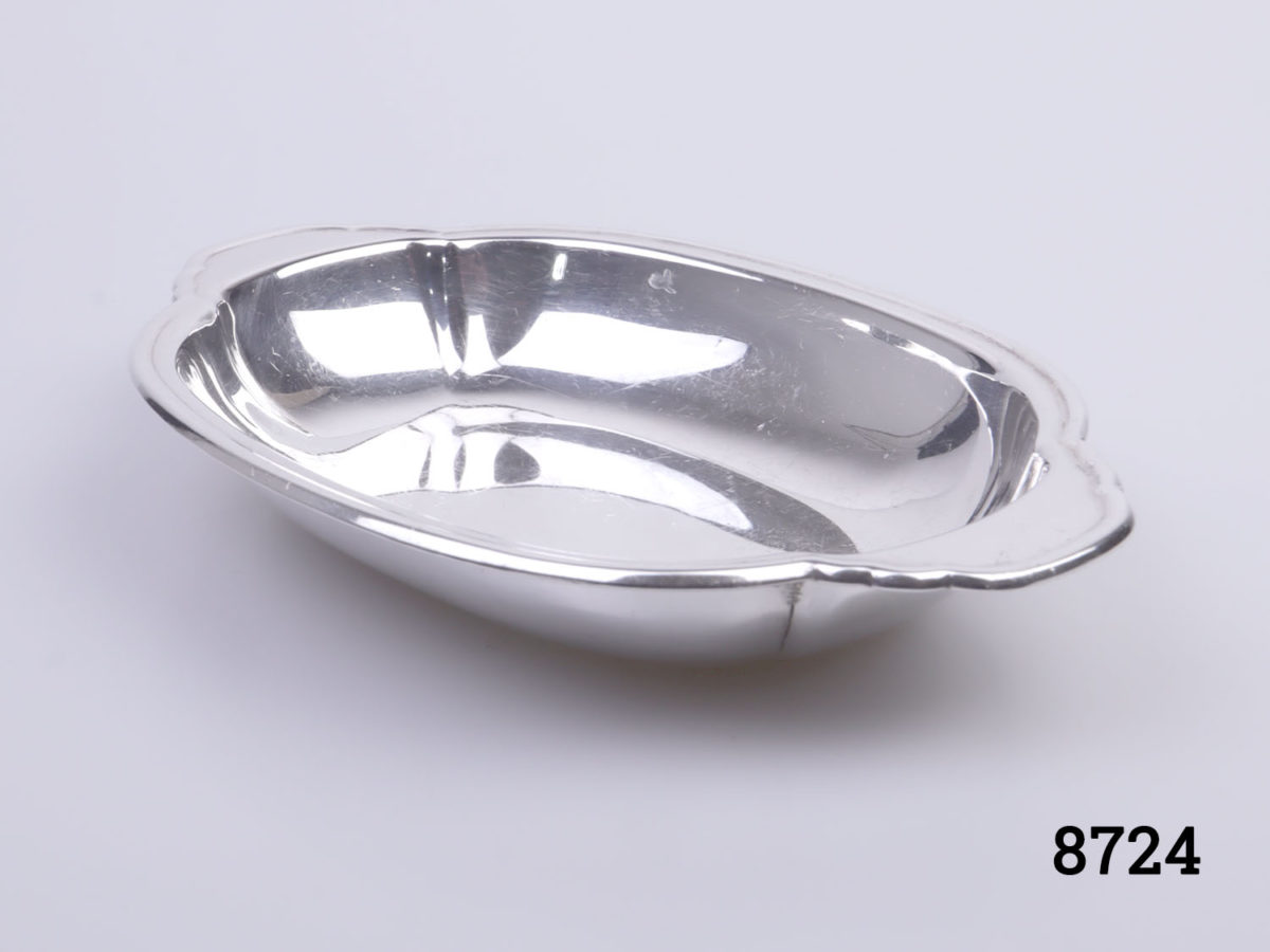 c1946 London assayed sterling silver trinket dish. Oval shaped dish with handles to the ends. Made by Louis Simpson Ltd Fully hallmarked to the base with Rd Number Photo of dish from an angled side view
