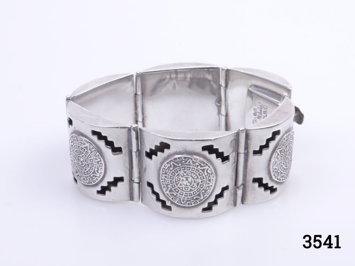 Vintage signed Mexican sterling silver bracelet. Chunky panel bracelet with Mayan calendar design to each panel. Fully hallmarked. Photo of bracelet displayed on a flat surface