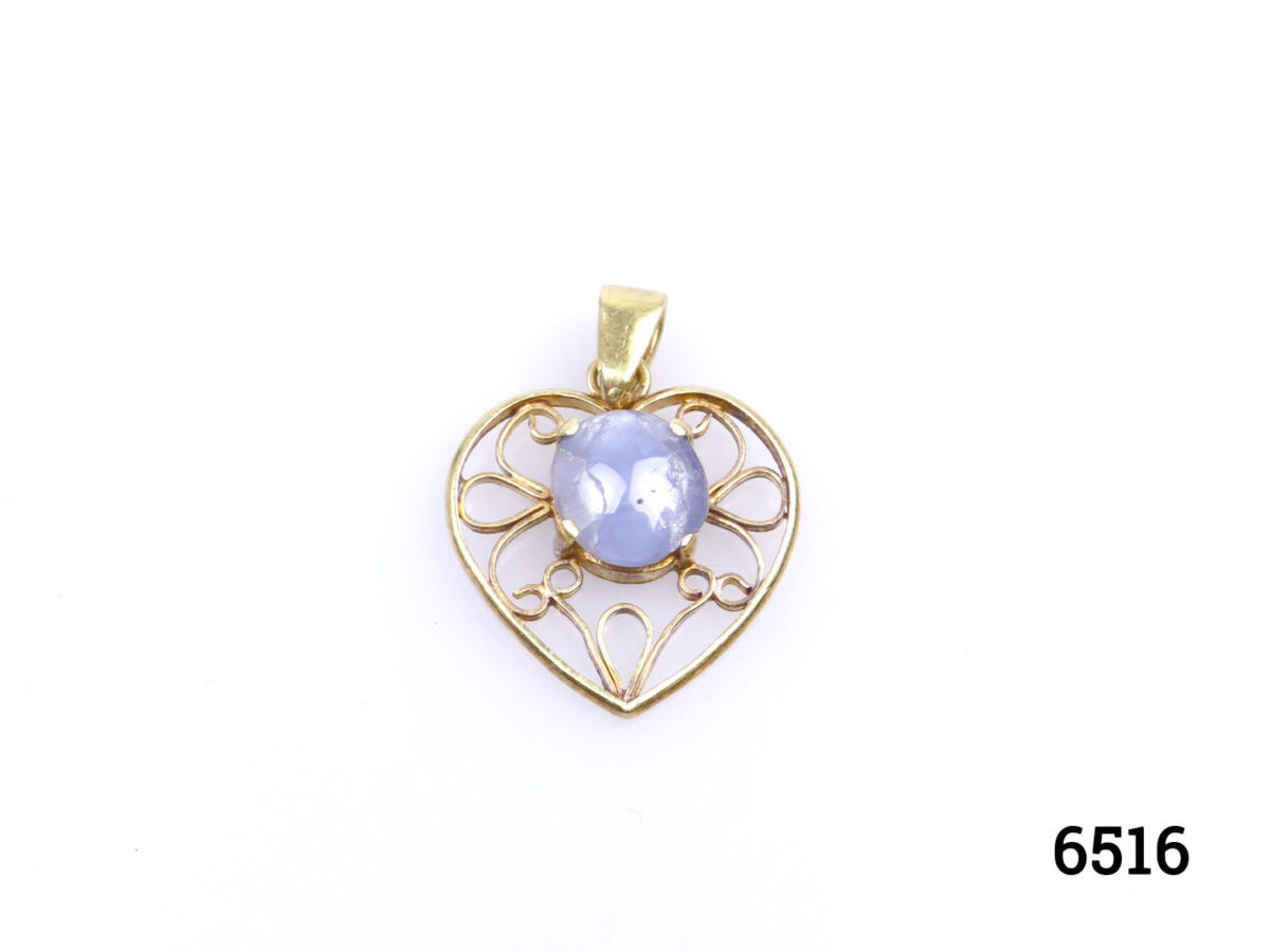 Vintage 18 karat gold heart pendant set with a star sapphire cabochon to the centre. Hallmarked GH18k on the pendant bail. Drop length 25mm Main photo of pendant on a flat surface shown right way up with bail to the top